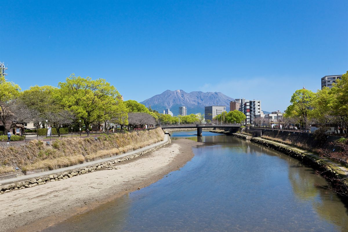 桜島を背景に流れる甲突川